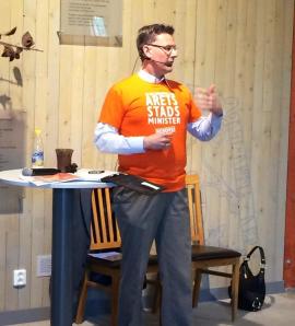 Kvällens moderator i full gång, prydligt klädd i en t-shirt som söker Stadsministerkandidater