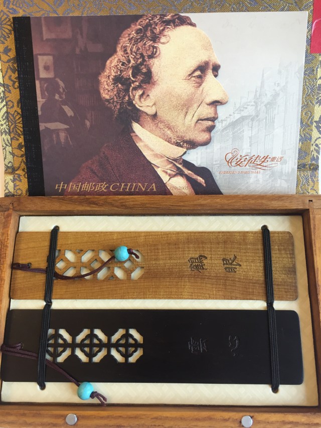 Gåva från Ningbo. Två bokmärke i trä och ett häfte med minnesfrimärke för att hylla H C Andersen 