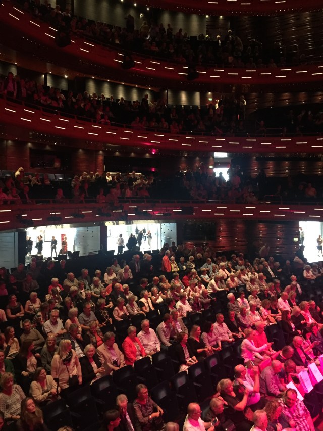 Salongen är fylld av en förväntansfull publik. 