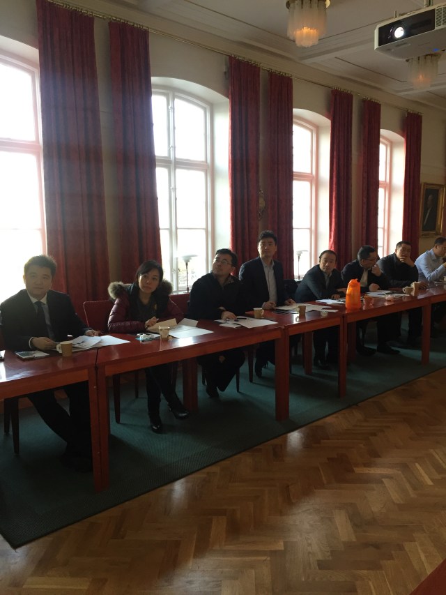 Delegationens ledamöter lyssnar intresserat och antecknar