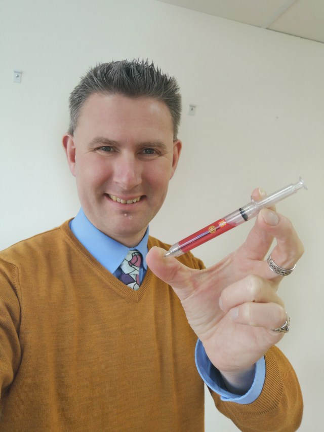 Jag håller pennan som ser ut som en spruta End Polio Now