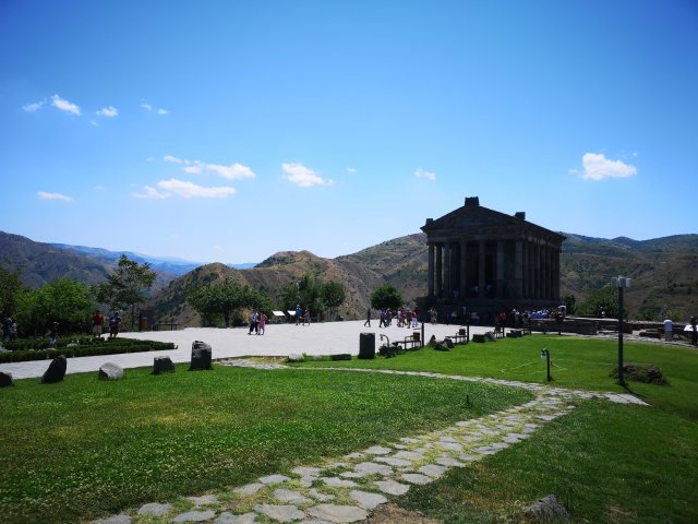 Jerevan Templet i Garni mot en blå himmel och de gröna bergen i bakgrunden