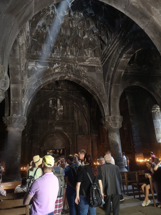 Jerevan Kyrkan som är mörk innuti lyses upp av en strimma ljus från ett hål i taket