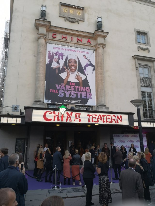Utanför teatern, på röda mattan, står en liten kör och sjunger gospel
